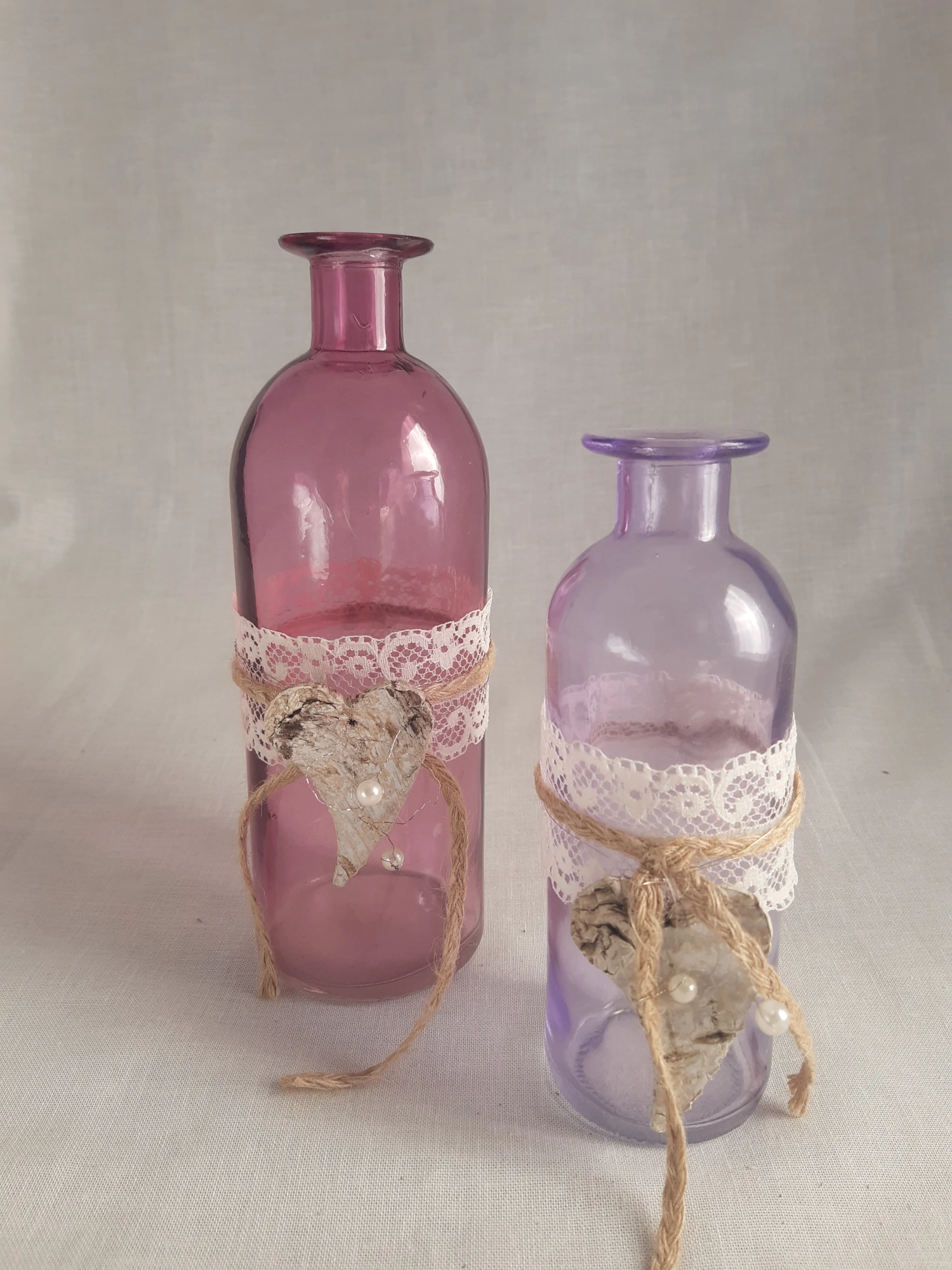 2 Vases en verre transparents colorés l'un en rose et l'autre en violet, une décoration naturelle avec un coeur en écorce de bouleau les agrémente